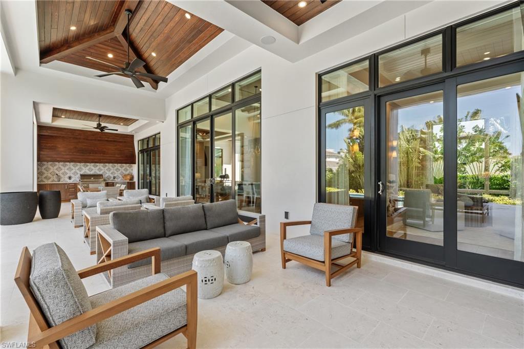 4511 Crayton Road Naples, FL 34103 - Photo 25 of 28 a living room with furniture and a floor to ceiling window