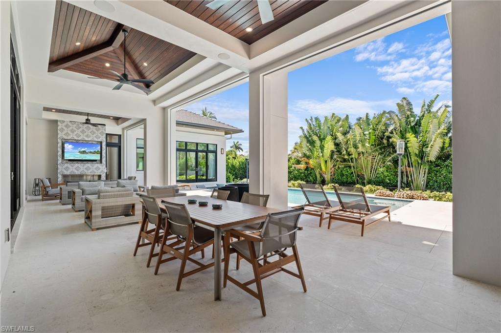 4511 Crayton Road Naples, FL 34103 - Photo 26 of 28 a view of a patio with a dining table and chairs