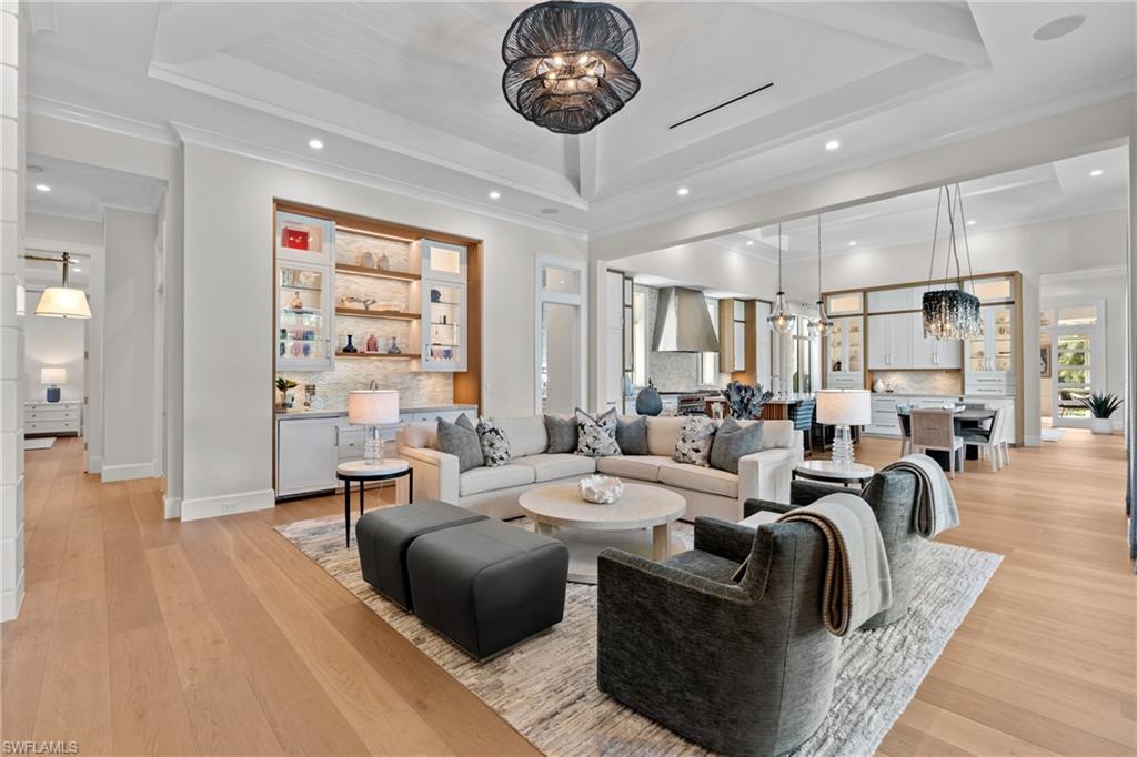 4511 Crayton Road Naples, FL 34103 - Photo 7 of 28 a living room with furniture a chandelier and a large window