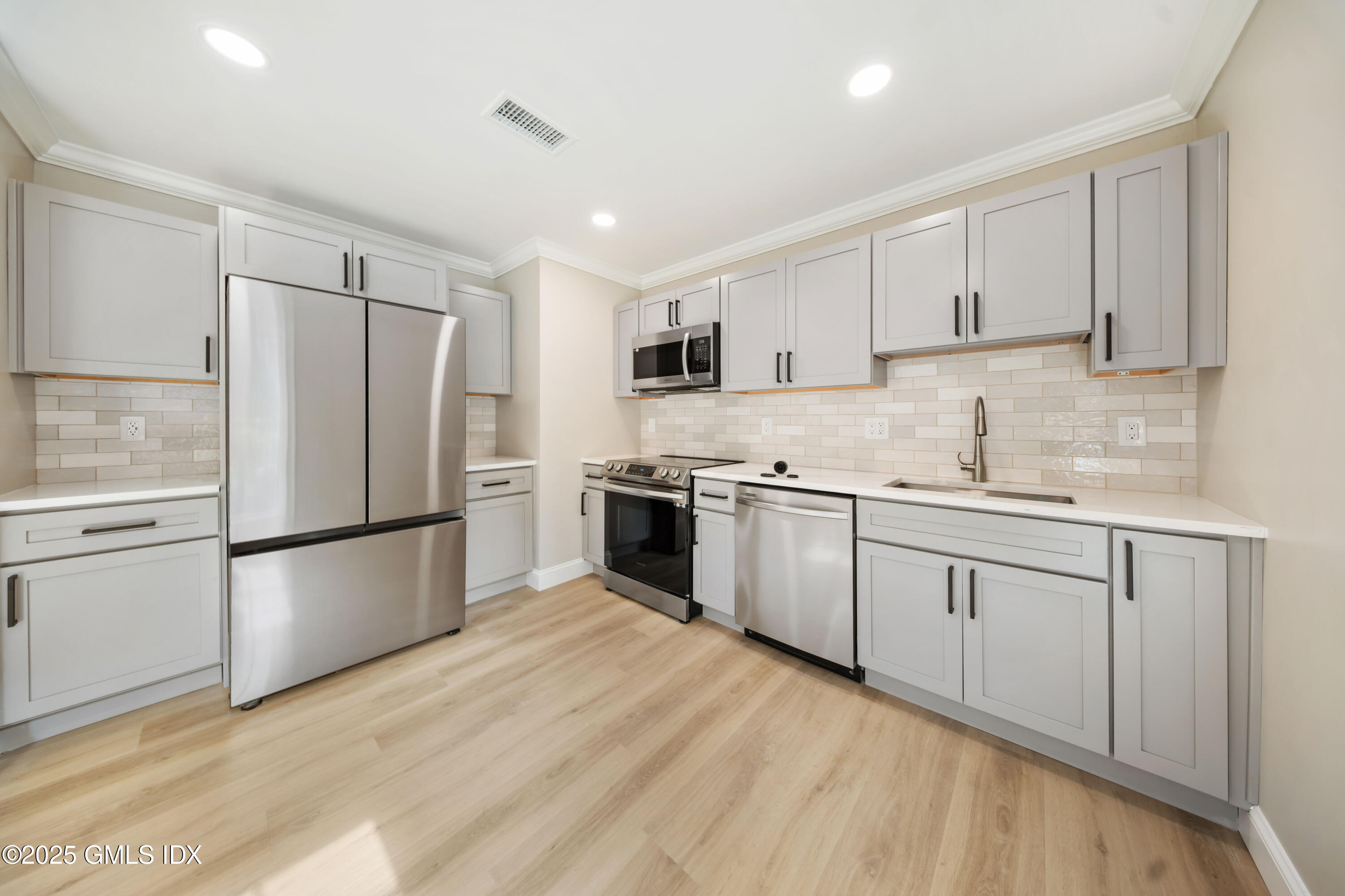 241 Weaver Street, Unit 12E Greenwich, CT 06831 - Photo 4 of 25 a kitchen with a white cabinets and white appliances