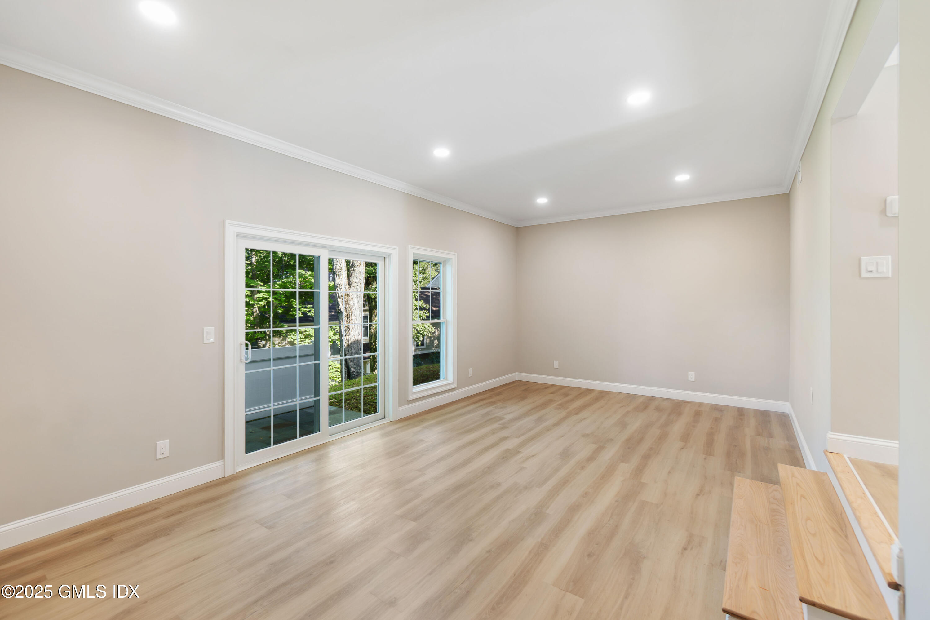 241 Weaver Street, Unit 12E Greenwich, CT 06831 - Photo 5 of 25 a view of an empty room with wooden floor and a window