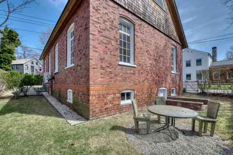 a backyard of a house with table and chairs