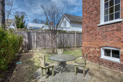 a backyard of a house with table and chairs