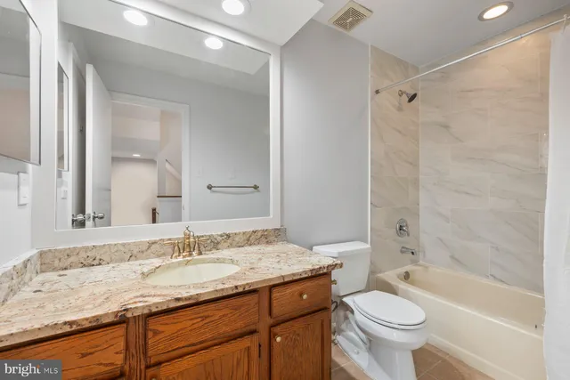 a bathroom with a granite countertop sink toilet and shower
