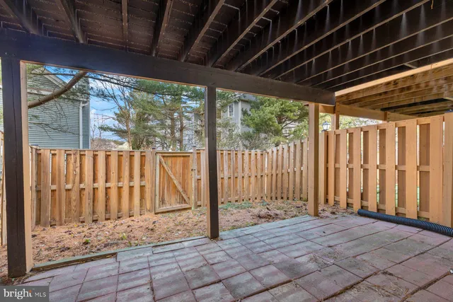 a view of backyard with large trees and wooden fence