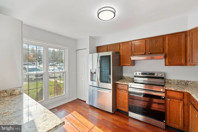 a kitchen with granite countertop a stove and a refrigerator