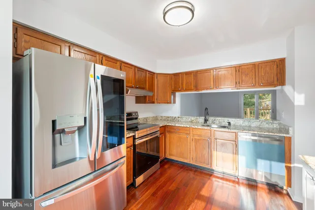 a kitchen with stainless steel appliances granite countertop a refrigerator and a sink