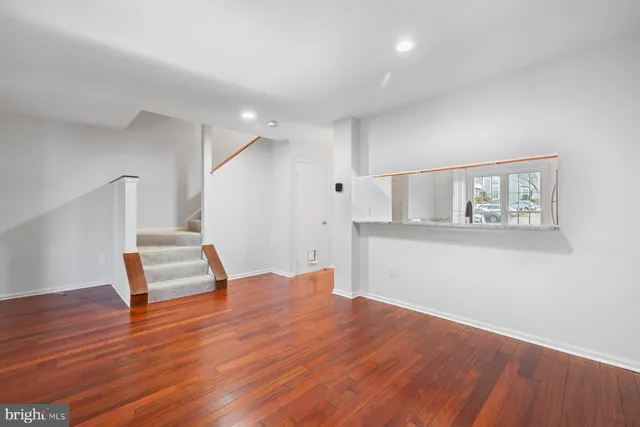 a view of empty room with wooden floor and window
