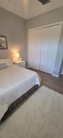 a bedroom with a bed and lamp on dresser