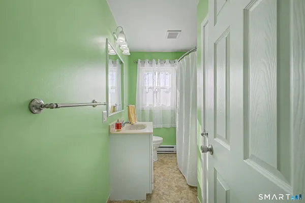 a bathroom with a sink a toilet and shower