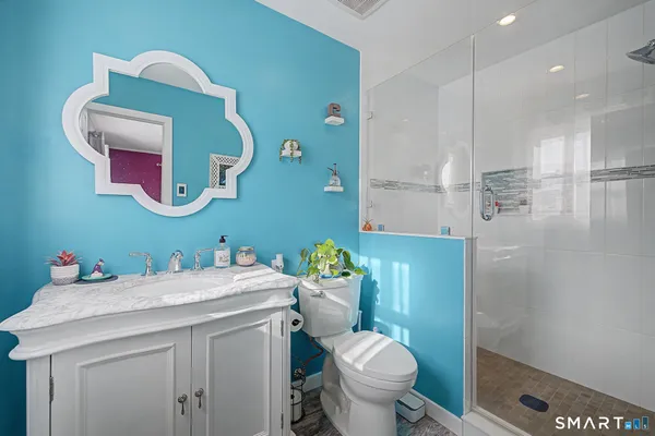 a bathroom with a sink a toilet and shower