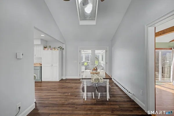 a view of a hallway with wooden floor and dining room view