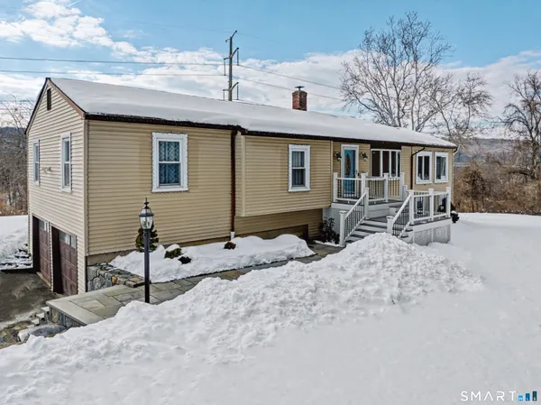 a view of a house with a yard covered in snow