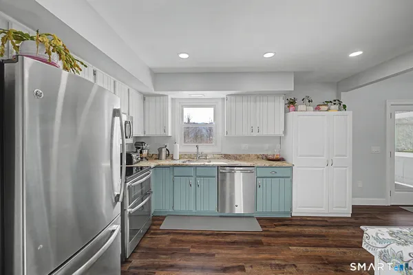 a kitchen with stainless steel appliances granite countertop a refrigerator and a stove