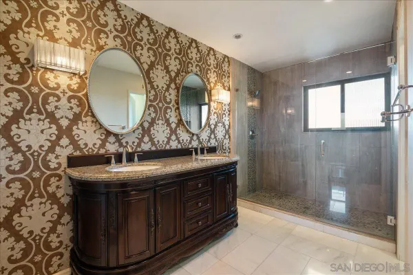 a bathroom with a double vanity sink mirror and shower