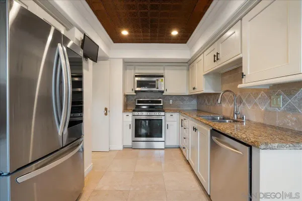 a kitchen with stainless steel appliances granite countertop a stove and a refrigerator