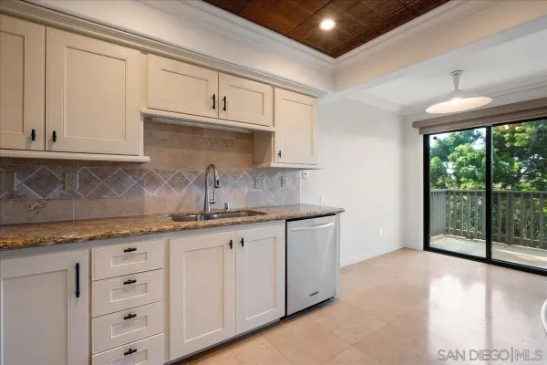 a kitchen with granite countertop white cabinets and a sink
