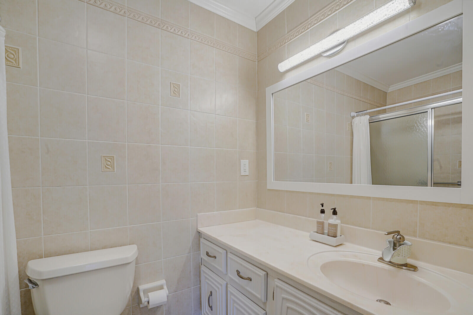 202 West High Point Terrace, Unit A Delray Beach, FL 33445 - Photo 22 of 55 a bathroom with a sink a toilet and mirror