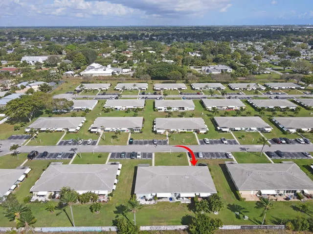 an aerial view of residential houses with outdoor space and parking