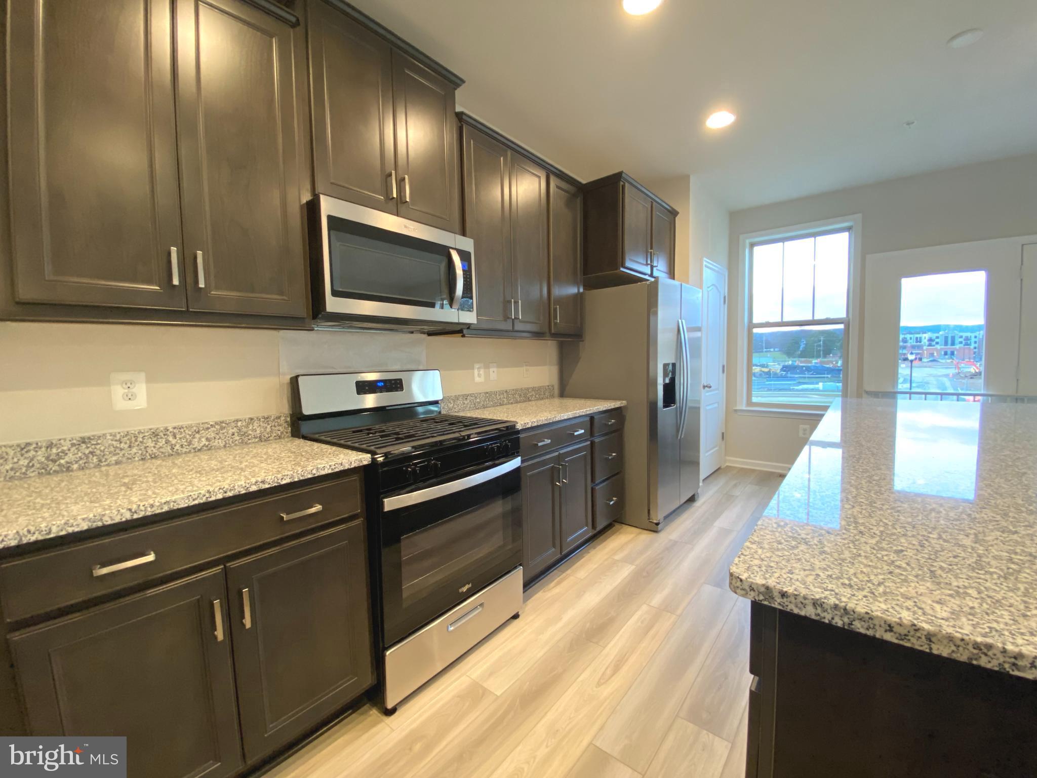 1659 Magundy Street Frederick, MD 21701 - Photo 4 of 16 a kitchen with granite countertop stainless steel appliances and wooden cabinets