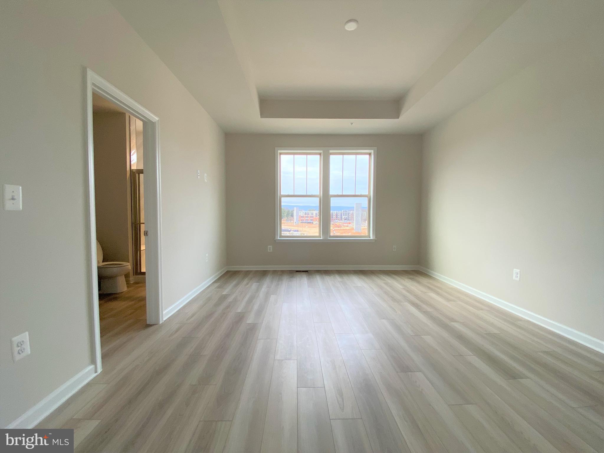 1659 Magundy Street Frederick, MD 21701 - Photo 7 of 16 an empty room with wooden floor and windows