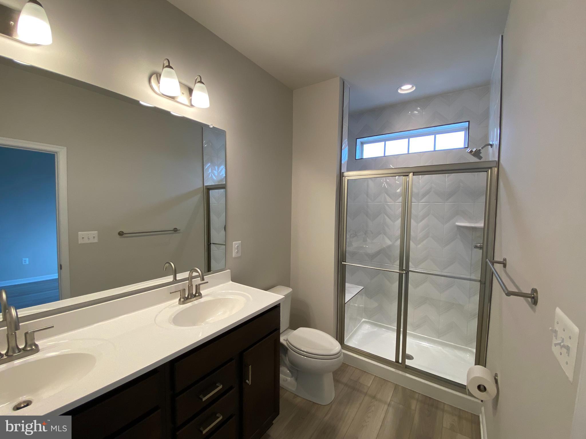 1659 Magundy Street Frederick, MD 21701 - Photo 10 of 16 a bathroom with a double vanity sink mirror and toilet