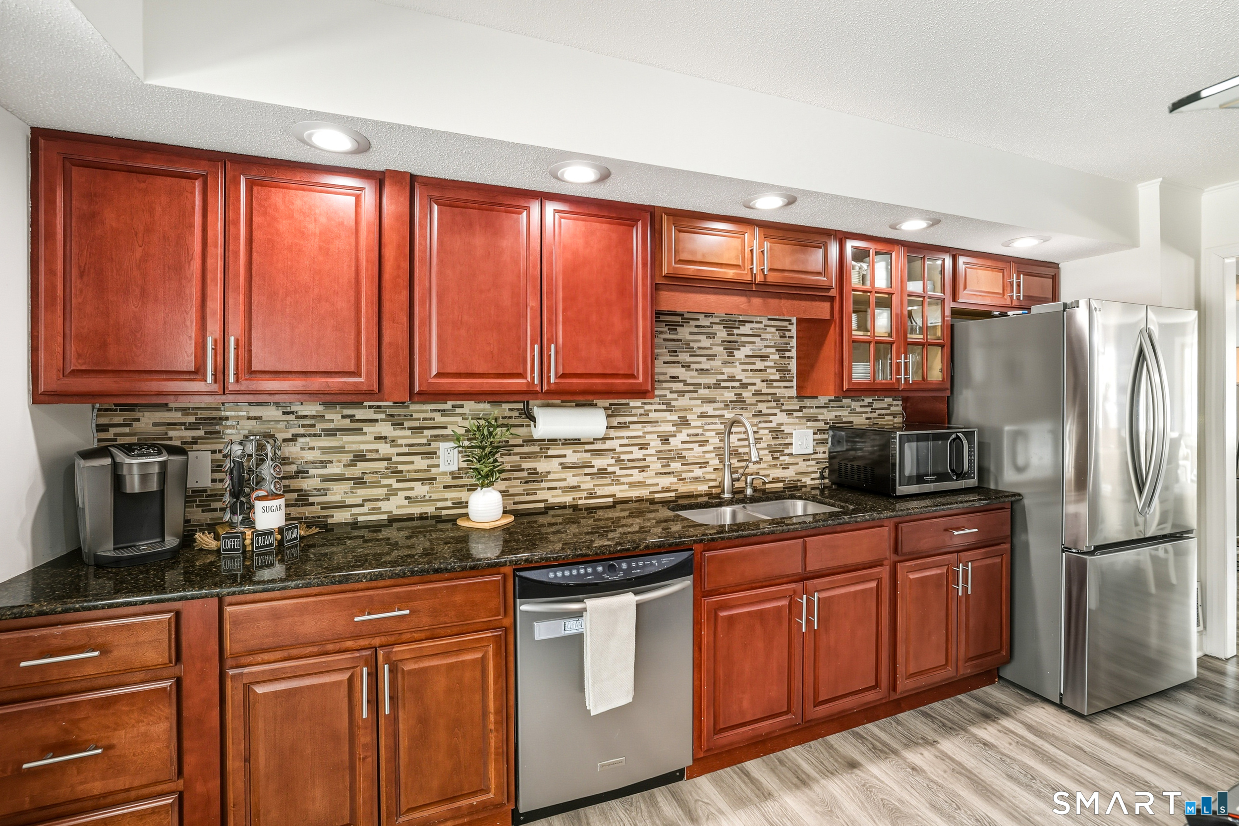 20 Wolf Hill Road, Unit 1A Wolcott, CT 06716 - Photo 14 of 36 Stylish Cherry cabinets, granite counters, tile backsplash, recessed lighting and newer stainless steel appliances