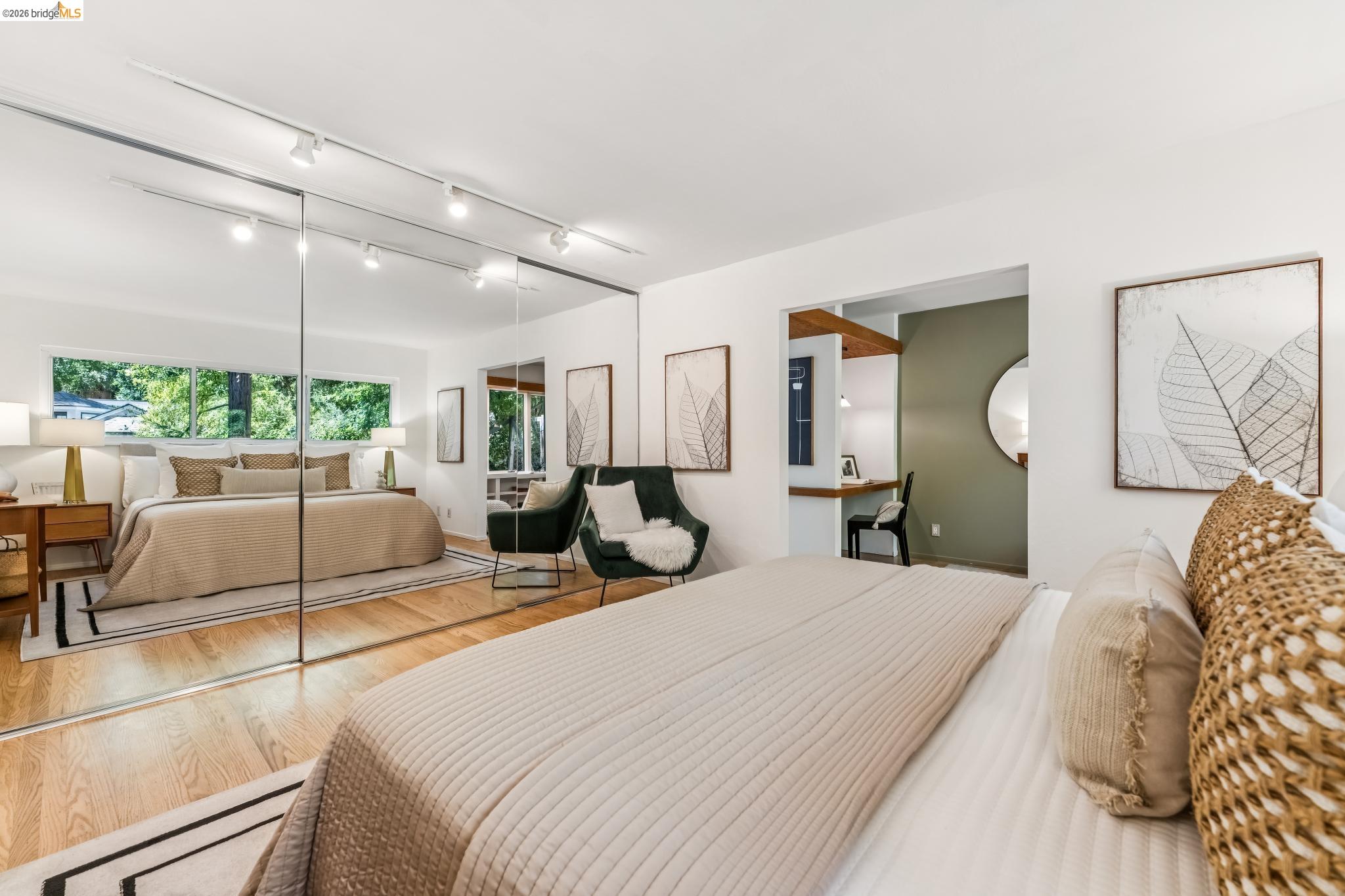 6645 Heather Ridge Way Oakland, CA 94611 - Photo 22 of 61 Bedroom featuring hardwood flooring, mirrored closet doors, a built-in desk area, and track lighting