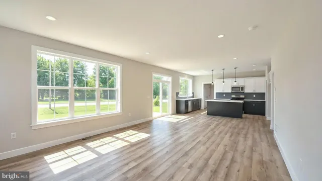a view of a kitchen with wooden floor and a window