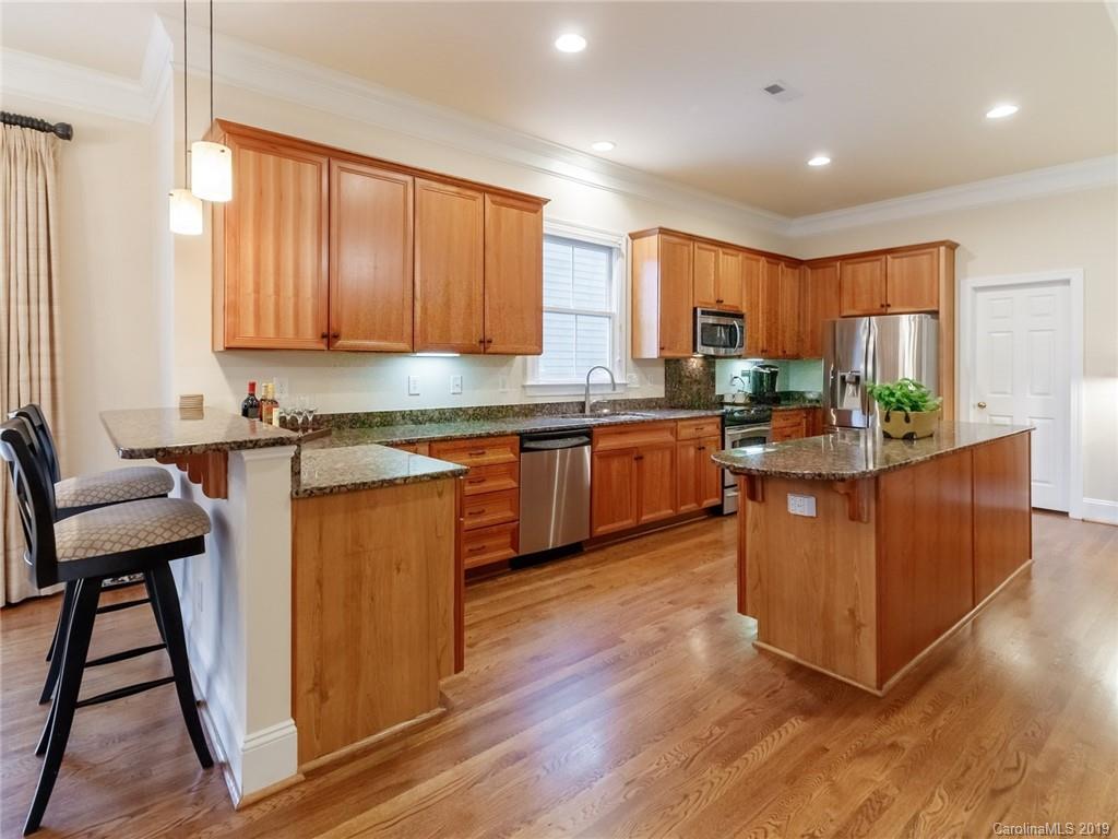 520 Fourth Baxter Crossing Fort Mill, SC 29708 - Photo 14 of 36 a kitchen with stainless steel appliances granite countertop wooden cabinets a dining table and chairs