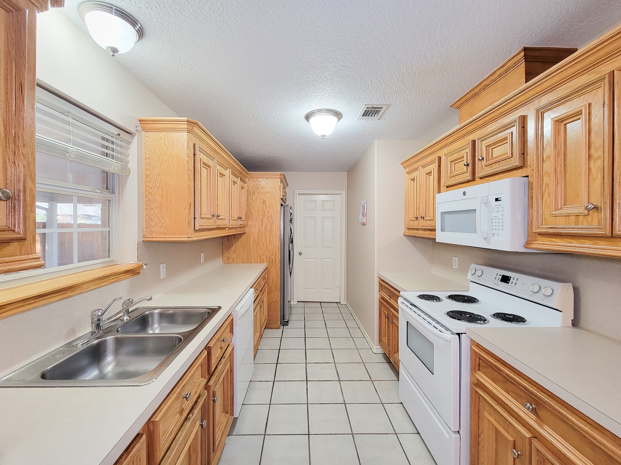 1000 Shell Avenue Cleveland, TX 77327 - Photo 15 of 34 a kitchen with stainless steel appliances granite countertop a sink and a stove next to a window