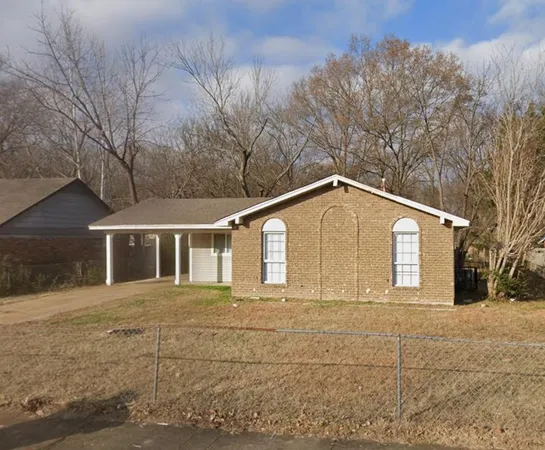 a front view of a house with yard and trees