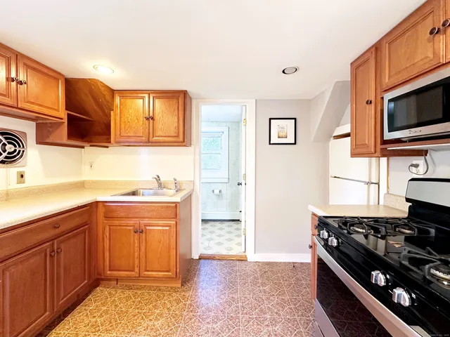 a kitchen with stainless steel appliances granite countertop a stove a sink and a refrigerator