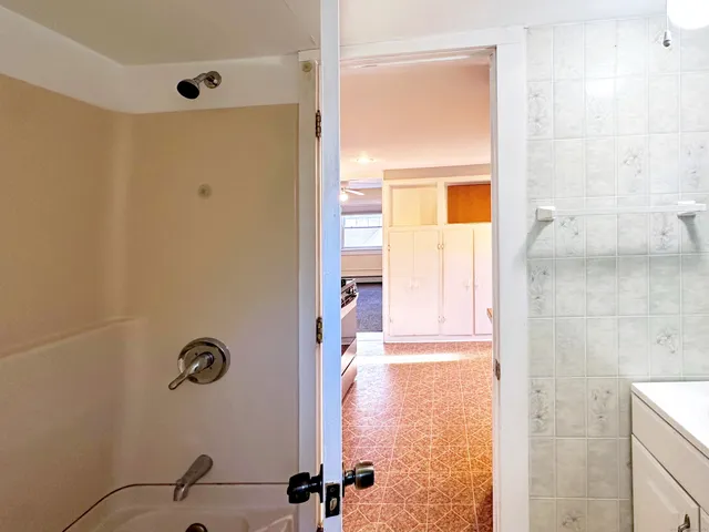 an empty room with a window and a ceiling fan