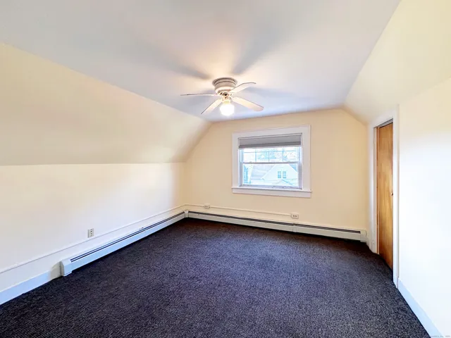 an empty room with a window and a ceiling fan