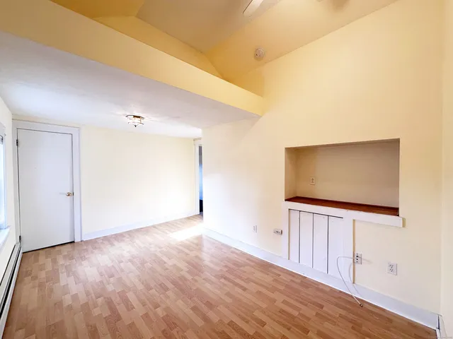 wooden floor in an empty room with a bathroom