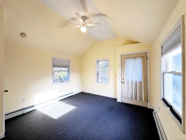 an empty room with a ceiling fan and a window
