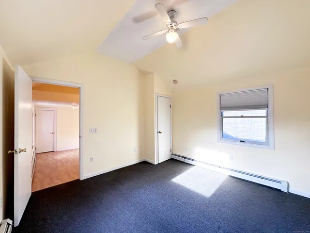 an empty room with a window and ceiling fan