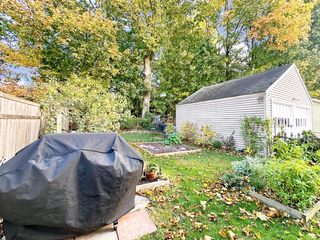 a view of a house with a backyard and trees