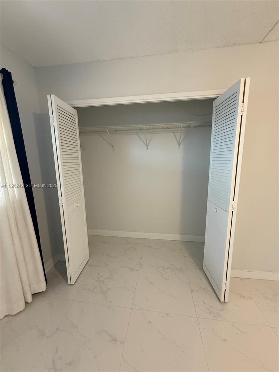 3091 North Course Drive, Unit 705 Pompano Beach, FL 33069 - Photo 11 of 30 an empty room with a bench