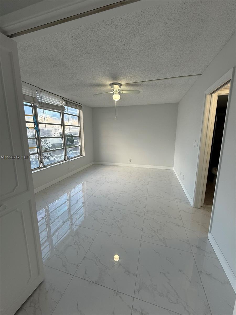 3091 North Course Drive, Unit 705 Pompano Beach, FL 33069 - Photo 24 of 30 an empty room with windows and fan