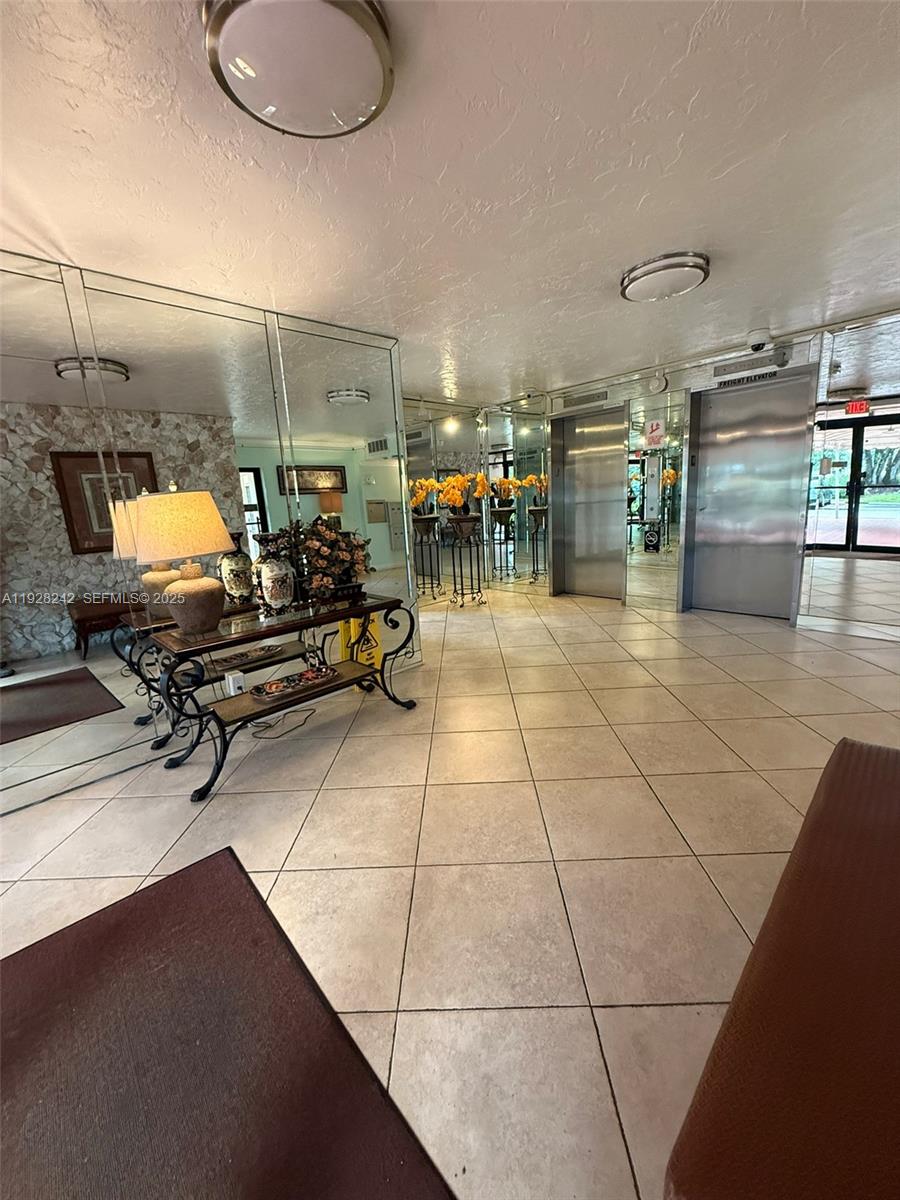 3091 North Course Drive, Unit 705 Pompano Beach, FL 33069 - Photo 6 of 30 a room with lots of chairs and mirrors