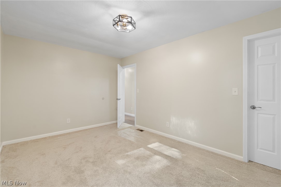 1075 Northeast River Road Lake Milton, OH 44429 - Photo 15 of 34 Spacious room featuring neutral carpeting, light-toned wall paint, and white trim