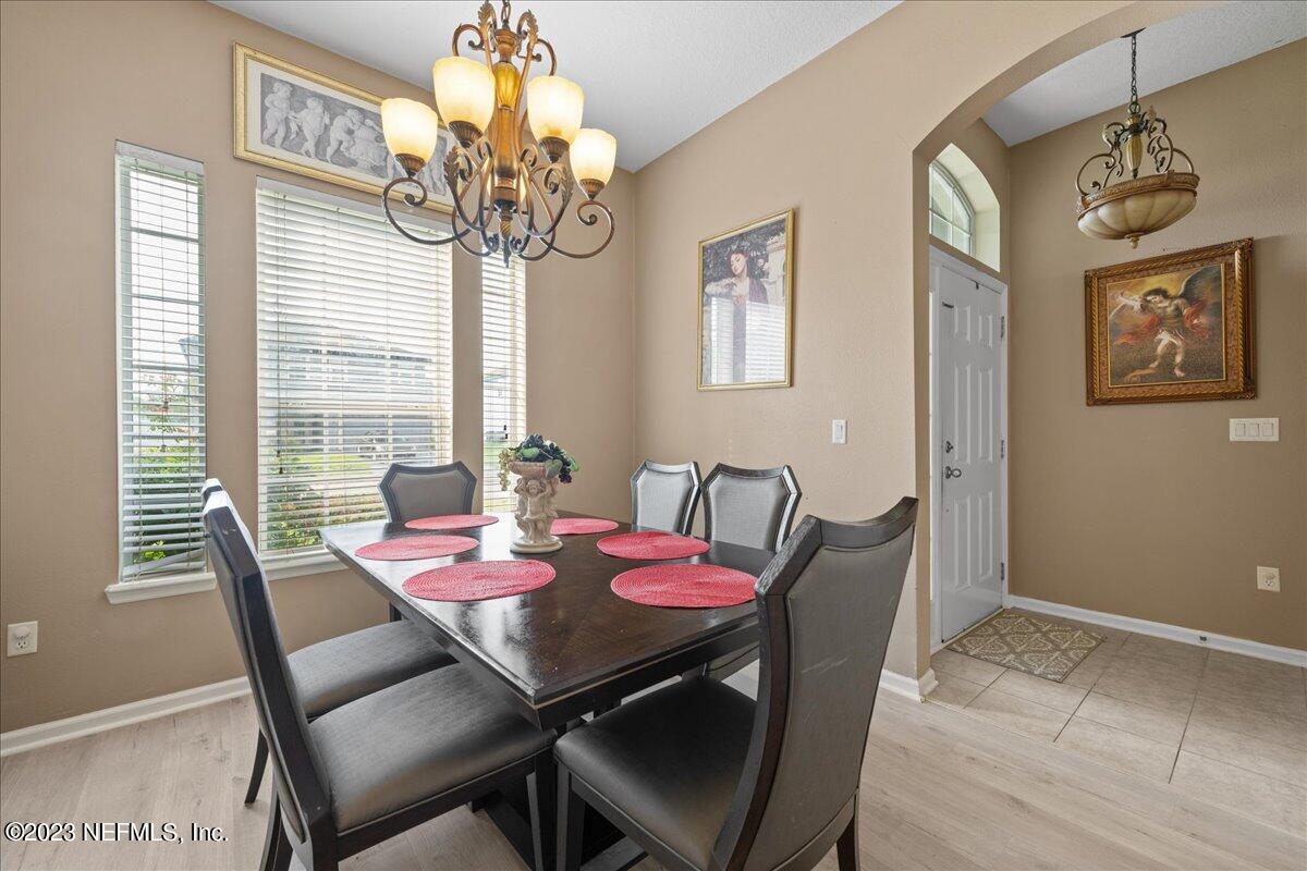 2861 Spoonbill Trail Orange Park, FL 32073 - Photo 11 of 23 a view of a dining room with furniture wooden floor and chandelier