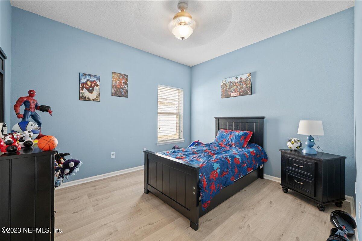 2861 Spoonbill Trail Orange Park, FL 32073 - Photo 14 of 23 a bedroom with a bed and a chandelier