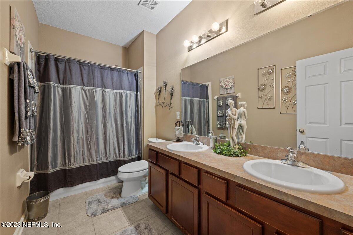2861 Spoonbill Trail Orange Park, FL 32073 - Photo 15 of 23 a bathroom with a double vanity sink toilet and a mirror