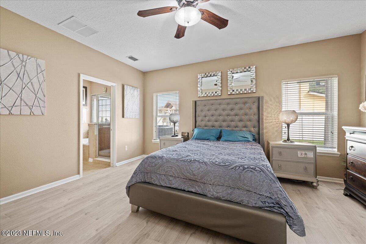 2861 Spoonbill Trail Orange Park, FL 32073 - Photo 16 of 23 a bedroom with a large bed and a chandelier