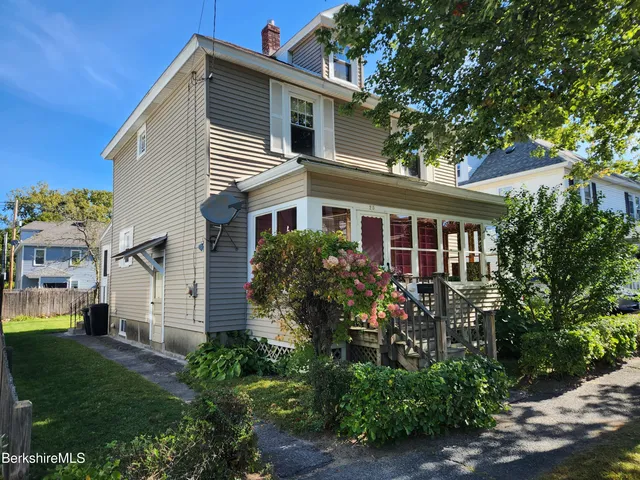 a view of house with a yard and sitting area