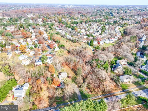 an aerial view of residential houses with outdoor space and trees