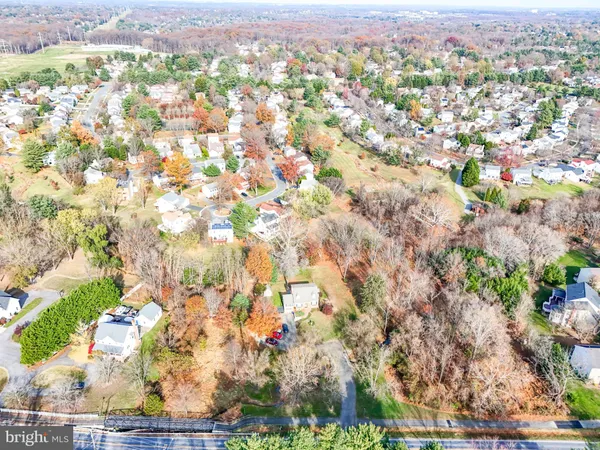 an aerial view of residential houses with outdoor space and trees